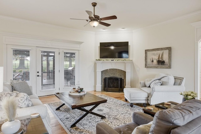 living room with light hardwood / wood-style flooring, ornamental molding, and ceiling fan