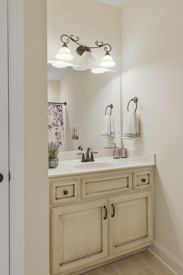 full bath with a shower with curtain, baseboards, and vanity