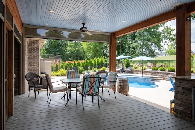 wooden deck featuring a fenced backyard, ceiling fan, a fenced in pool, and outdoor dining space