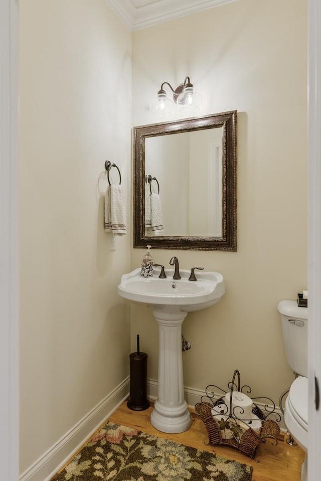 bathroom with hardwood / wood-style floors, ornamental molding, and toilet