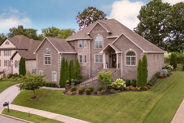 view of front of home with central air condition unit and a front lawn