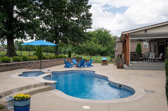 view of swimming pool featuring a patio, a pool with connected hot tub, fence, and a ceiling fan