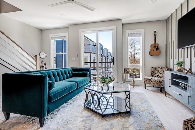 living room with light hardwood / wood-style flooring and ceiling fan