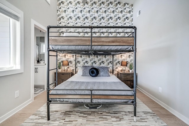 bedroom featuring a towering ceiling and hardwood / wood-style floors