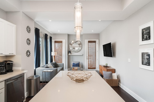 kitchen with decorative light fixtures, stainless steel dishwasher, dark hardwood / wood-style floors, and white cabinets