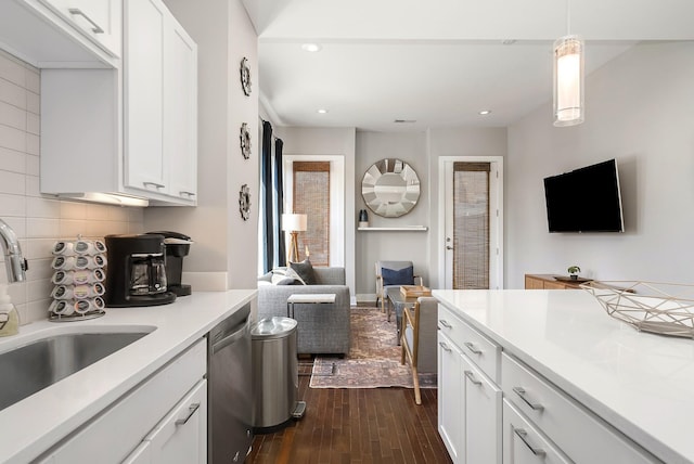 kitchen with decorative light fixtures, white cabinetry, sink, dark hardwood / wood-style flooring, and stainless steel dishwasher