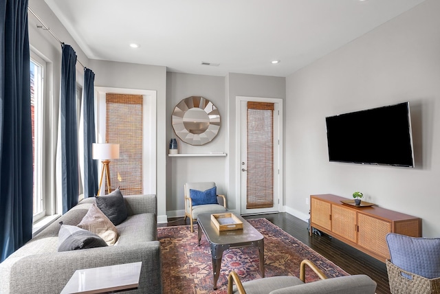 living room featuring a wealth of natural light and dark hardwood / wood-style flooring