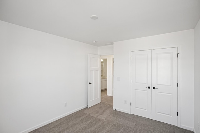 unfurnished bedroom with light colored carpet and a closet