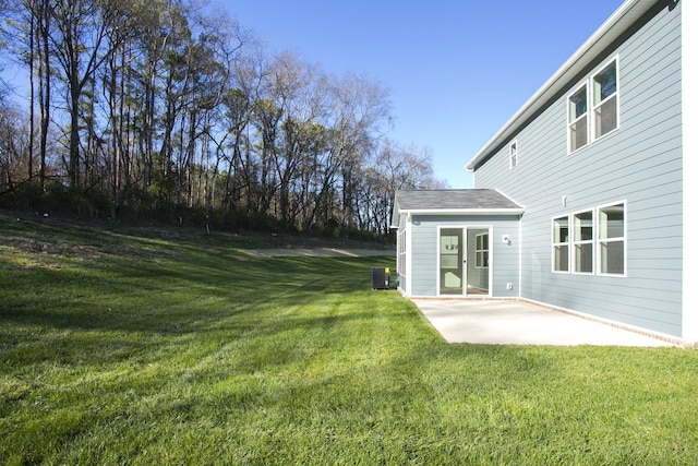 view of yard with central AC and a patio area