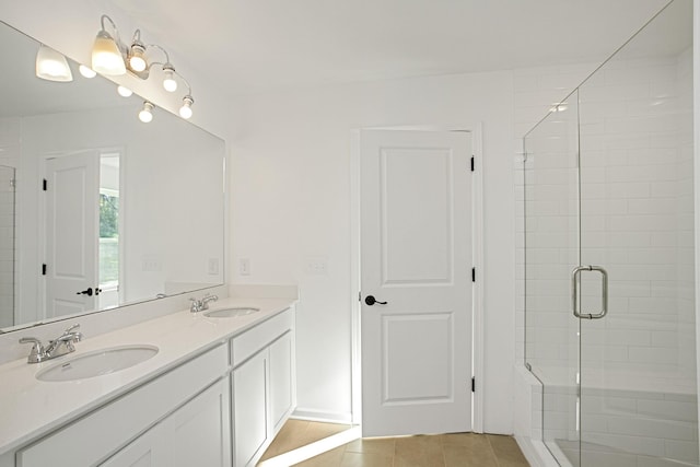 bathroom with an enclosed shower, vanity, and tile patterned floors