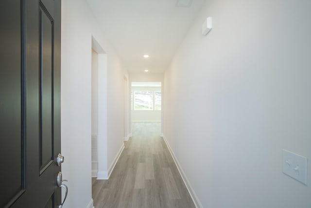 corridor with light hardwood / wood-style floors