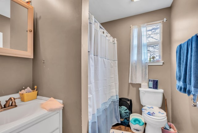 bathroom featuring vanity, toilet, and curtained shower