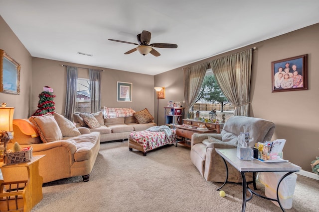 carpeted living room with ceiling fan