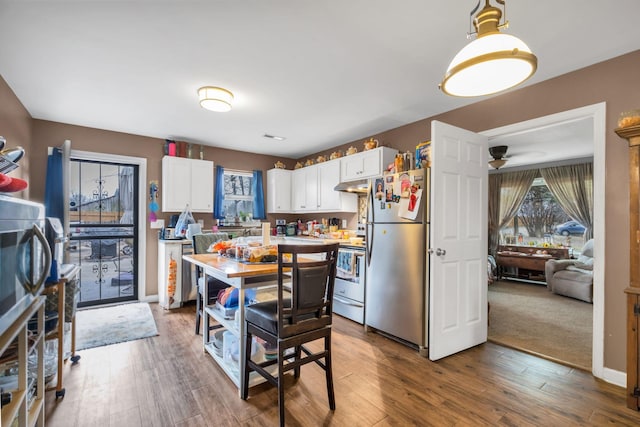 kitchen featuring stainless steel refrigerator, white cabinetry, hardwood / wood-style floors, and range with electric stovetop