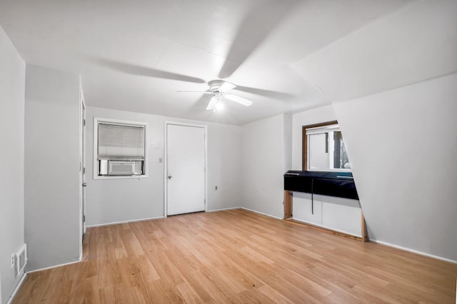 interior space with ceiling fan, cooling unit, and light wood-type flooring