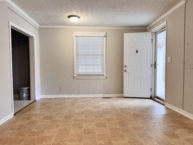 foyer entrance with ornamental molding and a textured ceiling