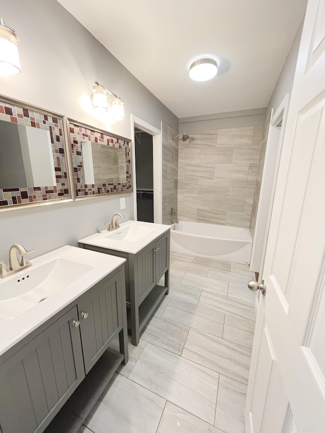 bathroom with tiled shower / bath combo and vanity