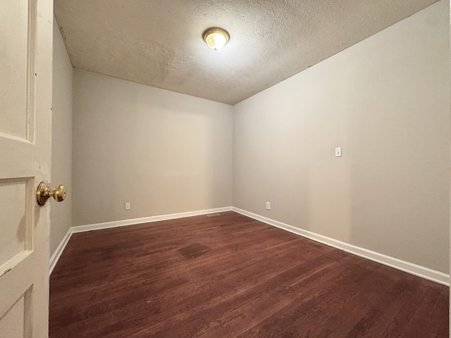 empty room with hardwood / wood-style floors and a textured ceiling