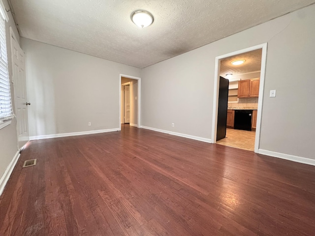 empty room featuring a textured ceiling and light wood-type flooring