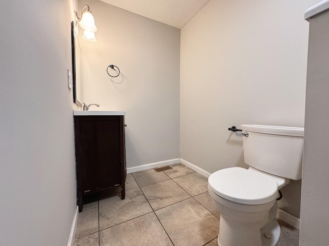 bathroom featuring tile patterned flooring, vanity, and toilet