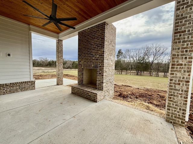 view of patio with an outdoor brick fireplace and a ceiling fan