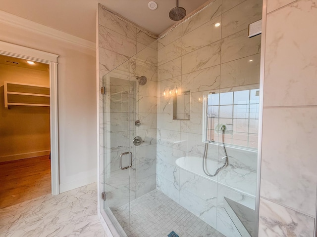 bathroom with baseboards, marble finish floor, a walk in closet, crown molding, and a shower stall