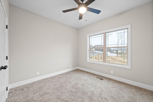 carpeted spare room featuring ceiling fan