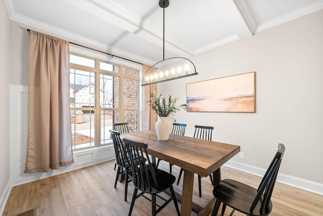 dining room featuring beam ceiling, ornamental molding, a chandelier, and light hardwood / wood-style floors