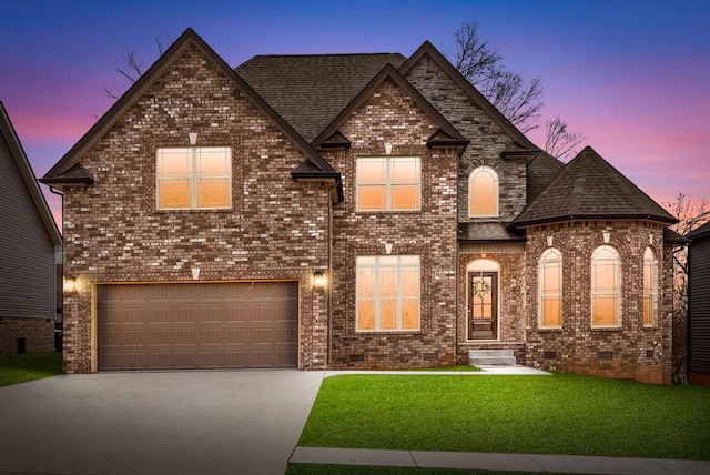 view of front of house featuring a garage and a lawn