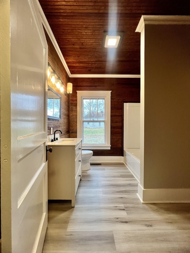 bathroom with wood ceiling, hardwood / wood-style flooring, vanity, a bath, and toilet