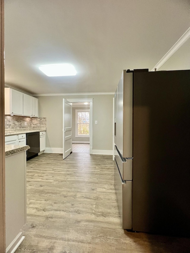 kitchen with white cabinetry, crown molding, stainless steel fridge, and dishwasher