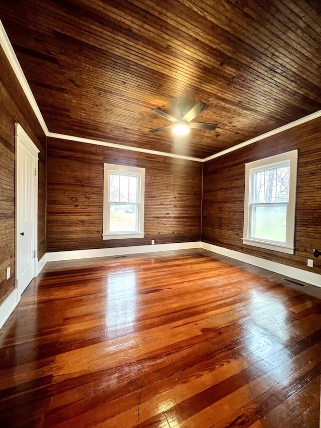 spare room with hardwood / wood-style flooring, crown molding, a wealth of natural light, and wood ceiling