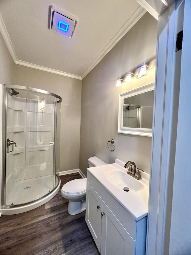 bathroom with hardwood / wood-style flooring, ornamental molding, vanity, and toilet