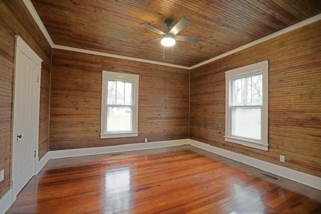 spare room with hardwood / wood-style flooring, ornamental molding, wooden ceiling, and ceiling fan