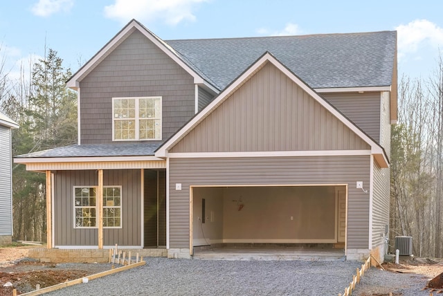 view of front facade featuring a garage, a porch, and central AC