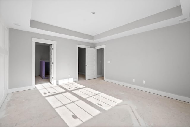 unfurnished bedroom with a raised ceiling