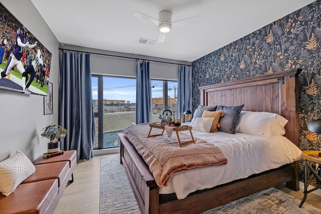635 7th Ave S Unit 211, Nashville, TN 37203 - bedroom with wallpapered walls, wood finished floors, and ceiling fan