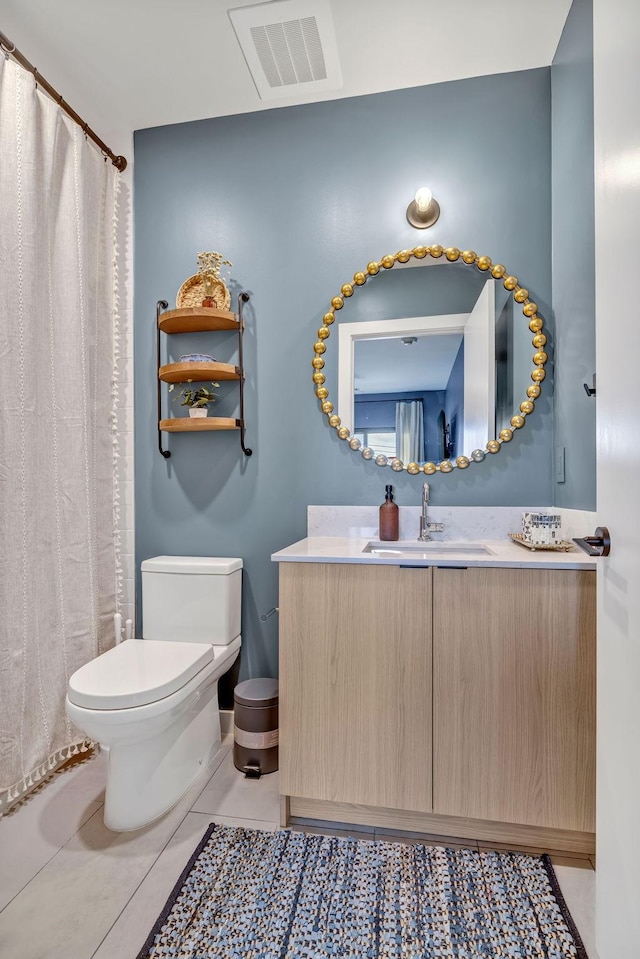 635 7th Ave S Unit 211, Nashville, TN 37203 - full bathroom featuring toilet, vanity, tile patterned floors, and curtained shower