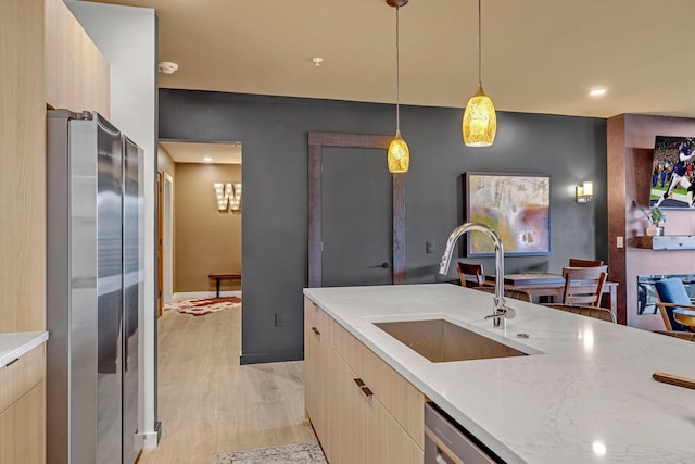 635 7th Ave S Unit 211, Nashville, TN 37203 - kitchen with a sink, freestanding refrigerator, modern cabinets, light brown cabinetry, and recessed lighting