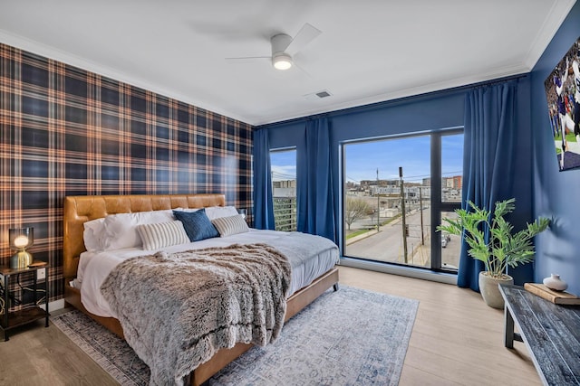 635 7th Ave S Unit 211, Nashville, TN 37203 - bedroom with ornamental molding, wallpapered walls, light wood-style floors, a ceiling fan, and access to exterior