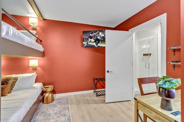 635 7th Ave S Unit 211, Nashville, TN 37203 - bedroom featuring wood finished floors, connected bathroom, and baseboards