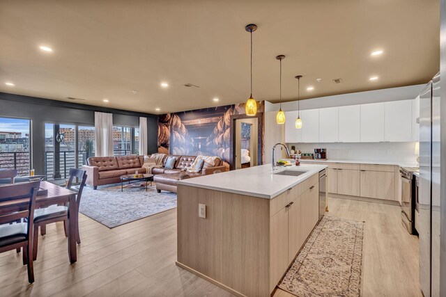 635 7th Ave S Unit 211, Nashville, TN 37203 - kitchen featuring a sink, modern cabinets, light brown cabinetry, stainless steel appliances, and light wood-type flooring