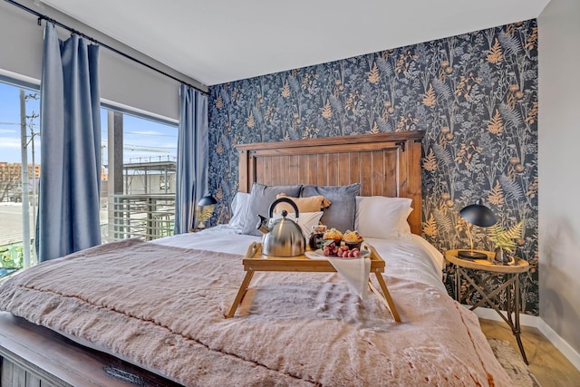 635 7th Ave S Unit 211, Nashville, TN 37203 - bedroom featuring baseboards, wallpapered walls, and wood finished floors