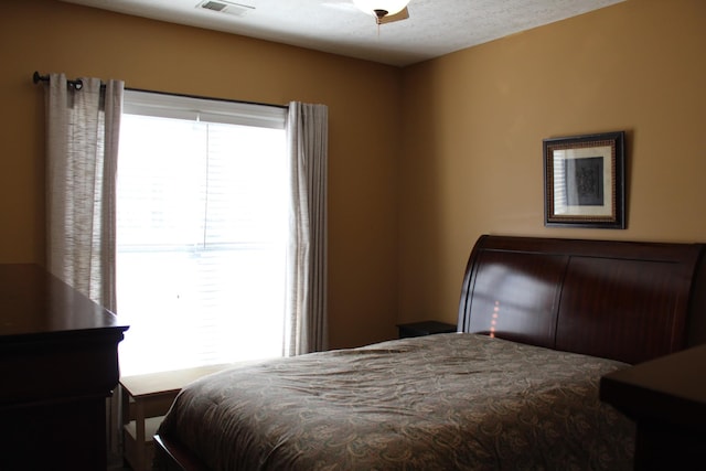 bedroom featuring visible vents, ceiling fan, and a textured ceiling