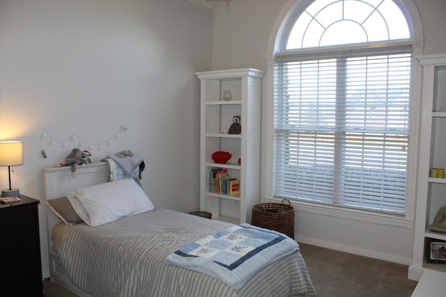 bedroom featuring baseboards, multiple windows, and carpet flooring