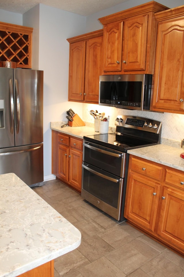 kitchen featuring stainless steel appliances and brown cabinetry