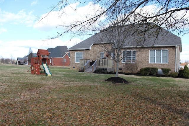 rear view of house featuring brick siding, crawl space, a playground, and a lawn