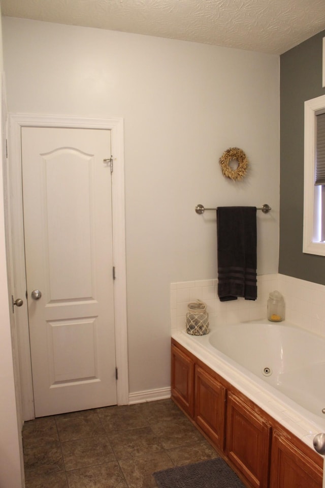 bathroom featuring a whirlpool tub and a textured ceiling