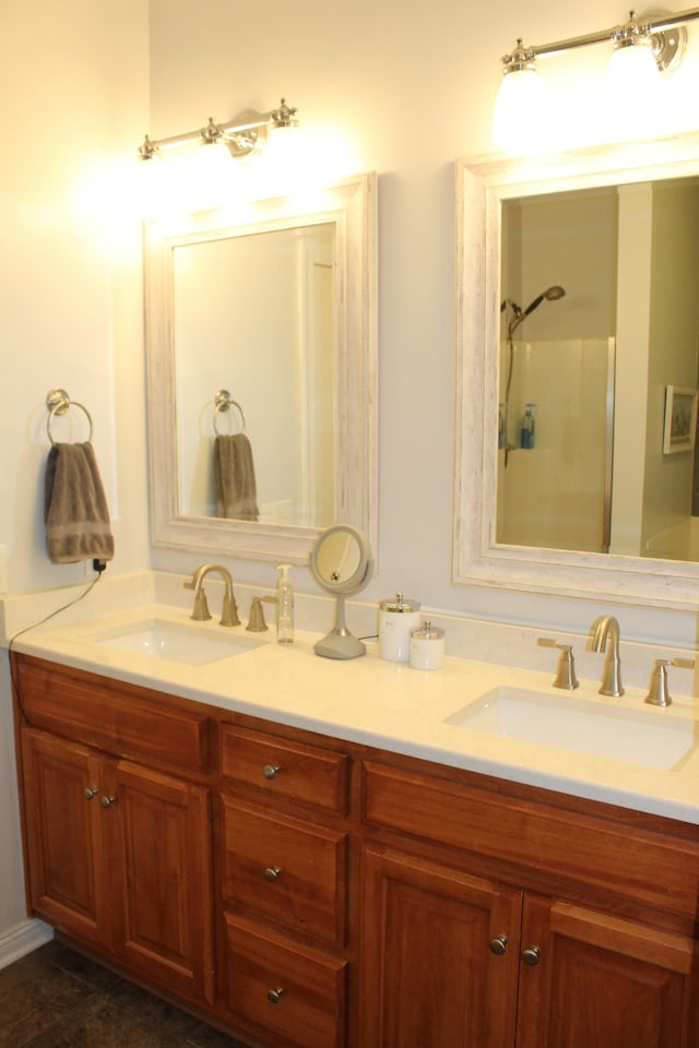 full bathroom with double vanity, a shower, and a sink