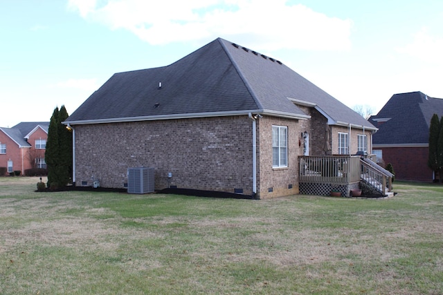 rear view of house with crawl space, central air condition unit, a lawn, and brick siding